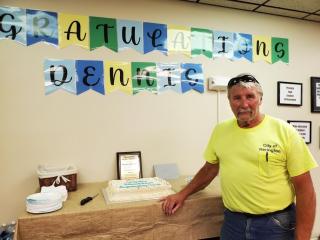 Dennis receiving his retirement plaque and cake on June 17th