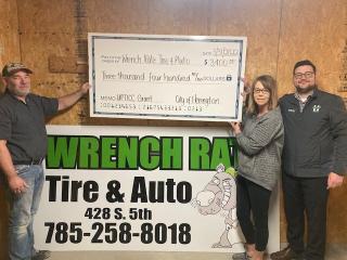 City Manager Branden Dross presents Jason and Sara DeWitt of Wrench Rats Tire & Auto with a $3400 UPTICC check