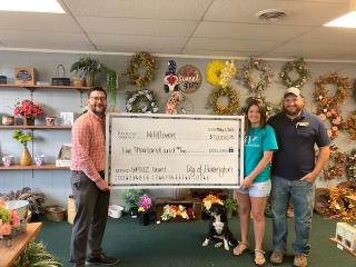 City Manager Branden Dross presenting the UPTICC grant check to Chris and Rachel Barnes